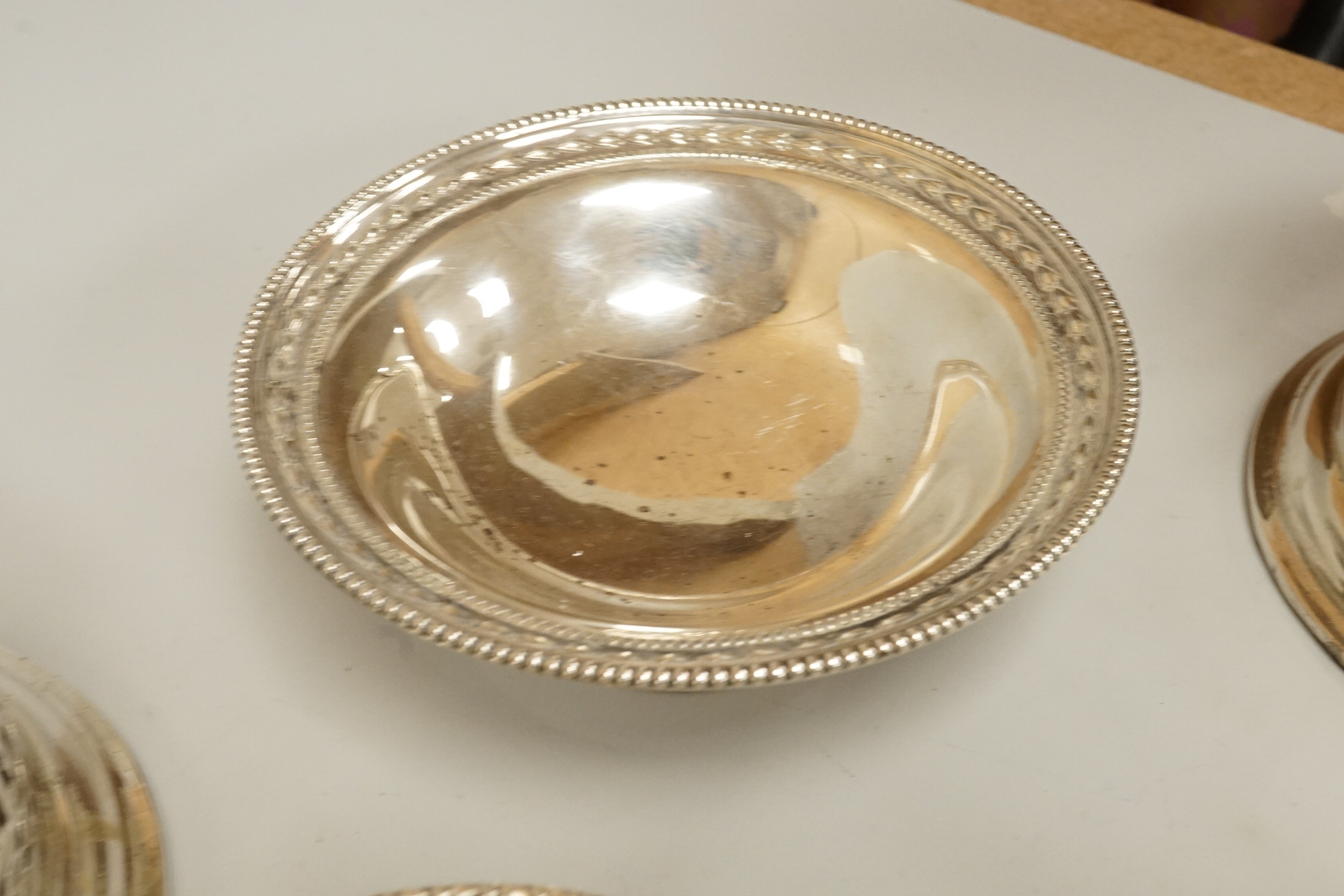 Two pairs of early 20th century silver bonbon dishes, including smallest by Mappin & Webb, Birmingham, 1913, height 6cm, together with an Edwardian silver butter shell and a pair of Edwardian silver mounted bottle coaste